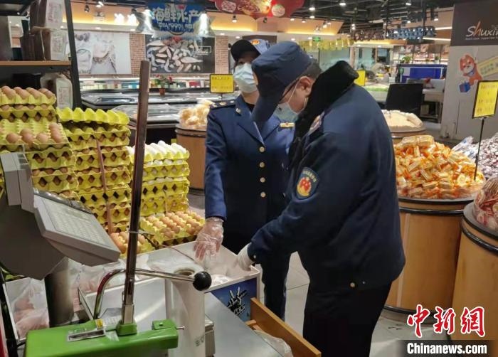 圖為疫情期間，甘肅嘉峪關(guān)市場監(jiān)管局工作人員檢查蔬菜市場。　 柴佳楠 　攝