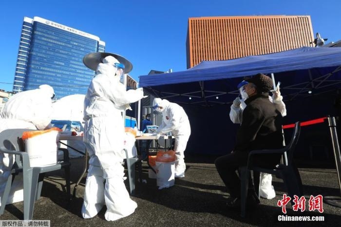 資料圖：韓國(guó)首爾，醫(yī)務(wù)人員對(duì)市民進(jìn)行新冠病毒檢測(cè)。