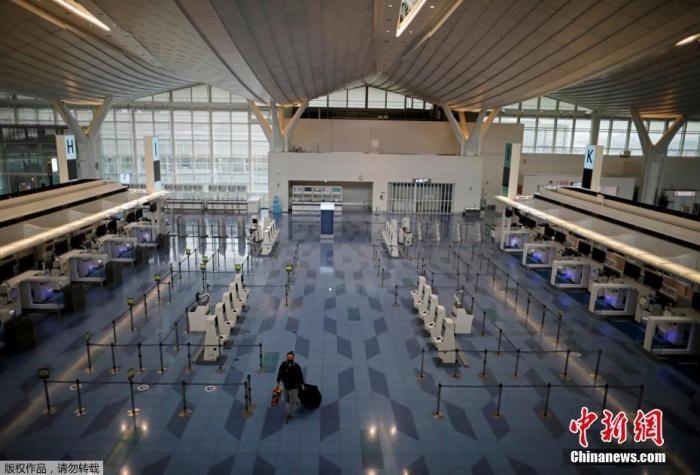 資料圖：日本東京，東京國(guó)際機(jī)場(chǎng)，一名乘客在國(guó)際航班航站樓的登機(jī)區(qū)。