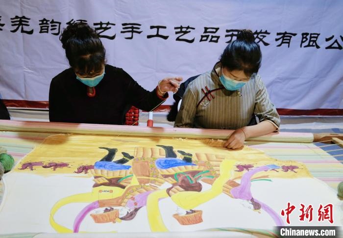 圖為皮繡藝人在市集上“秀”指尖技藝?！●R銘言 攝