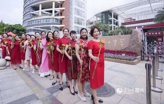 6月7日一早，廈門雙十中學(xué)考生家長們身穿旗袍，手拿向日葵在考場外為孩子加油打氣，寓意“旗開得勝，一舉奪魁”。人民網(wǎng)記者 陳博攝