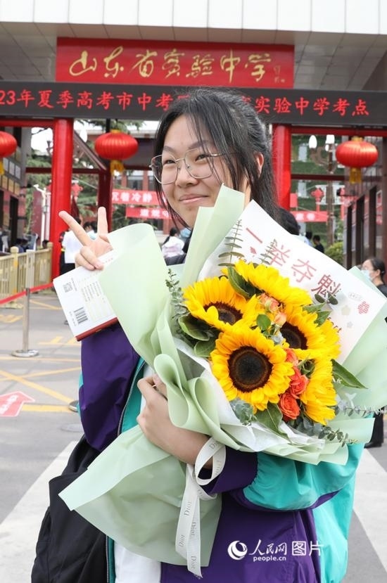 6月7日高考首日，山東67萬考生走進考場，拼搏逐夢。在山東省實驗中學(xué)考點，考生進考場前手捧向日葵花拍照留念，寓意“一舉奪魁”。人民網(wǎng)記者 劉祺攝