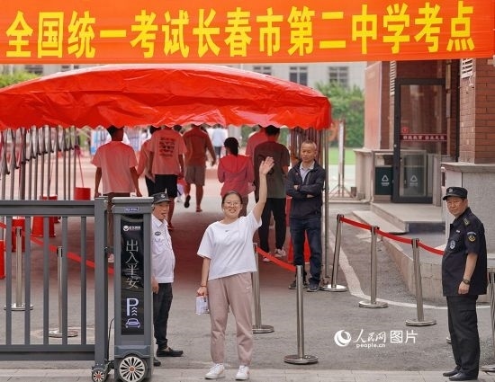 6月7日，在長春市第二中學(xué)考點，一名考生信心滿滿進入考場，并與家長揮手致意。人民網(wǎng)記者 李洋攝