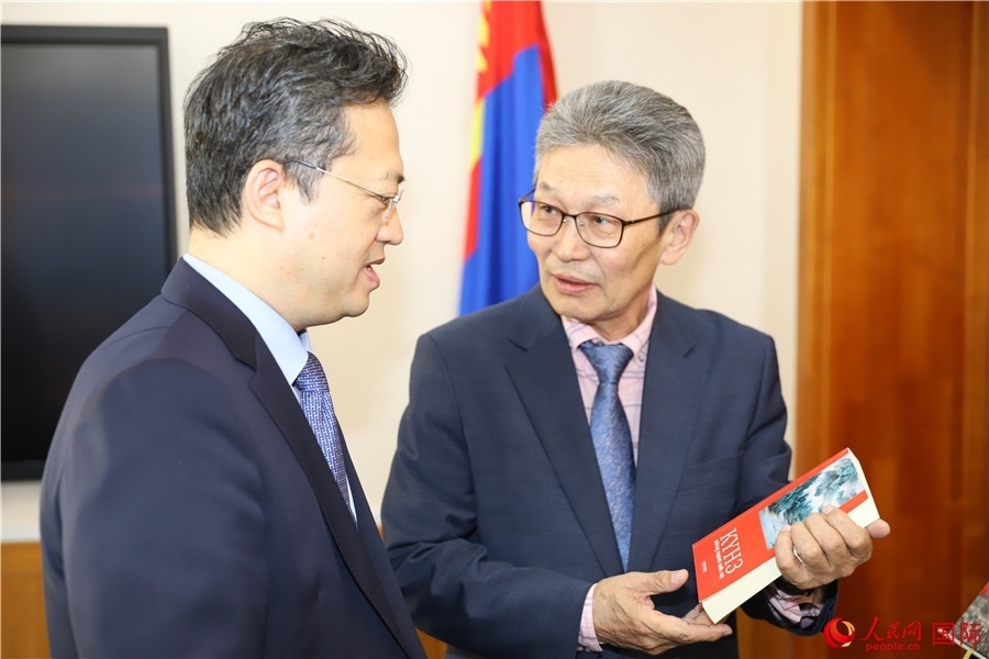 其米德策耶（右一）向李峙介紹翻譯成果。人民網(wǎng)記者 霍文攝