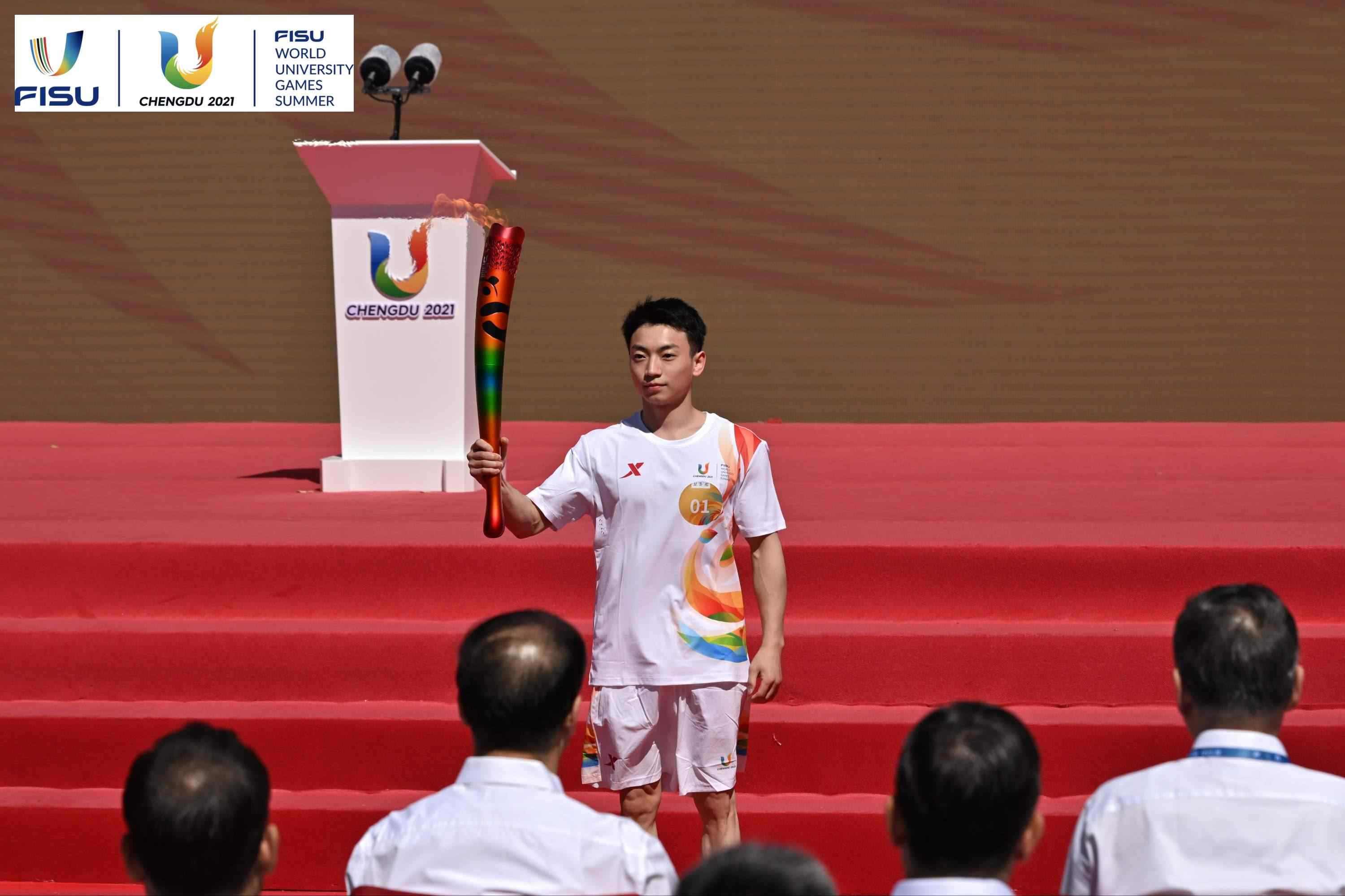 成都大運會火炬手、奧運冠軍鄒敬園高舉火炬。 圖片來源：成都大運會執(zhí)委會供圖