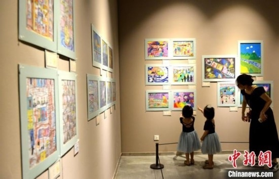 圖為家長帶著孩子參觀展覽。呂明 攝