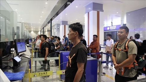 6月13日，乘坐中老鐵路國際旅客列車的旅客在磨憨邊檢大廳排隊候檢。李揚 攝