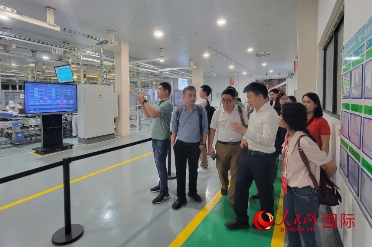 廣汽埃安工作人員向外媒記者進(jìn)行介紹。人民網(wǎng) 寧玉瑛攝