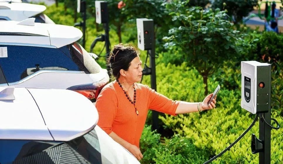 2023年5月24日，山東省膠州市新立街小區(qū)內(nèi)一位居民使用電動汽車充電樁掃碼充電。該小區(qū)加裝各類智慧設(shè)備，打造“智慧社區(qū)”，為居民生活帶來便利。