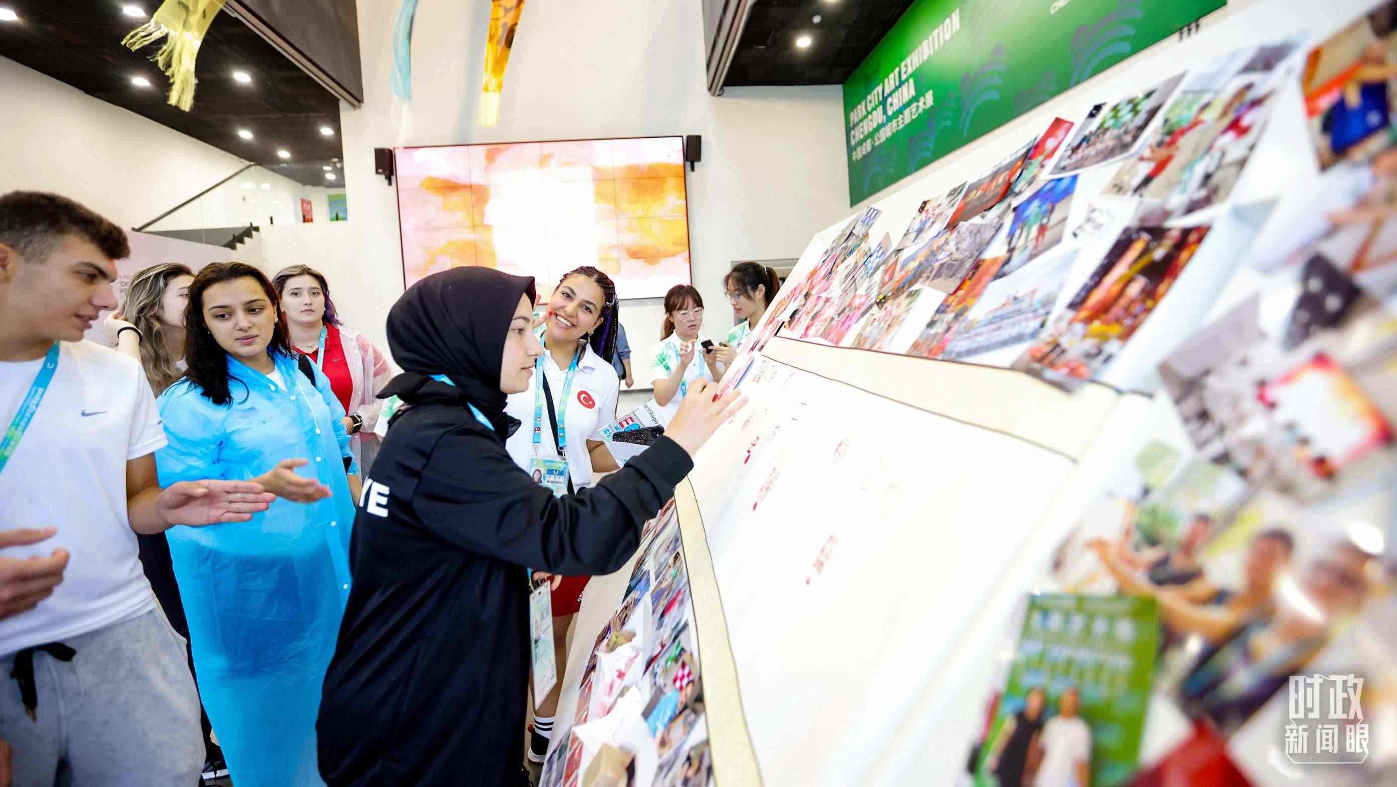 各國青年運動員正在參觀成都大運村內(nèi)的“雪山下的公園城市，煙火里的幸福成都”主題藝術(shù)展。（總臺央視記者魏幫軍拍攝）