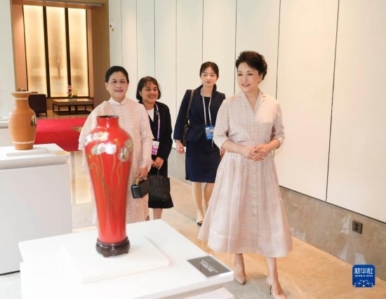 7月27日下午，國家主席習近平夫人彭麗媛在四川成都會見陪同印度尼西亞總統(tǒng)佐科來華出席第31屆世界大學生夏季運動會開幕式并訪華的總統(tǒng)夫人伊莉亞娜。這是彭麗媛和伊莉亞娜欣賞成都特色非遺工藝品。新華社記者 丁林 攝