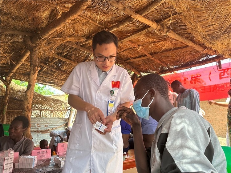 圖為南昌大學第一附屬醫(yī)院病理科主治醫(yī)師張振東為村民解說藥品使用方法。中國駐乍得醫(yī)療隊供圖