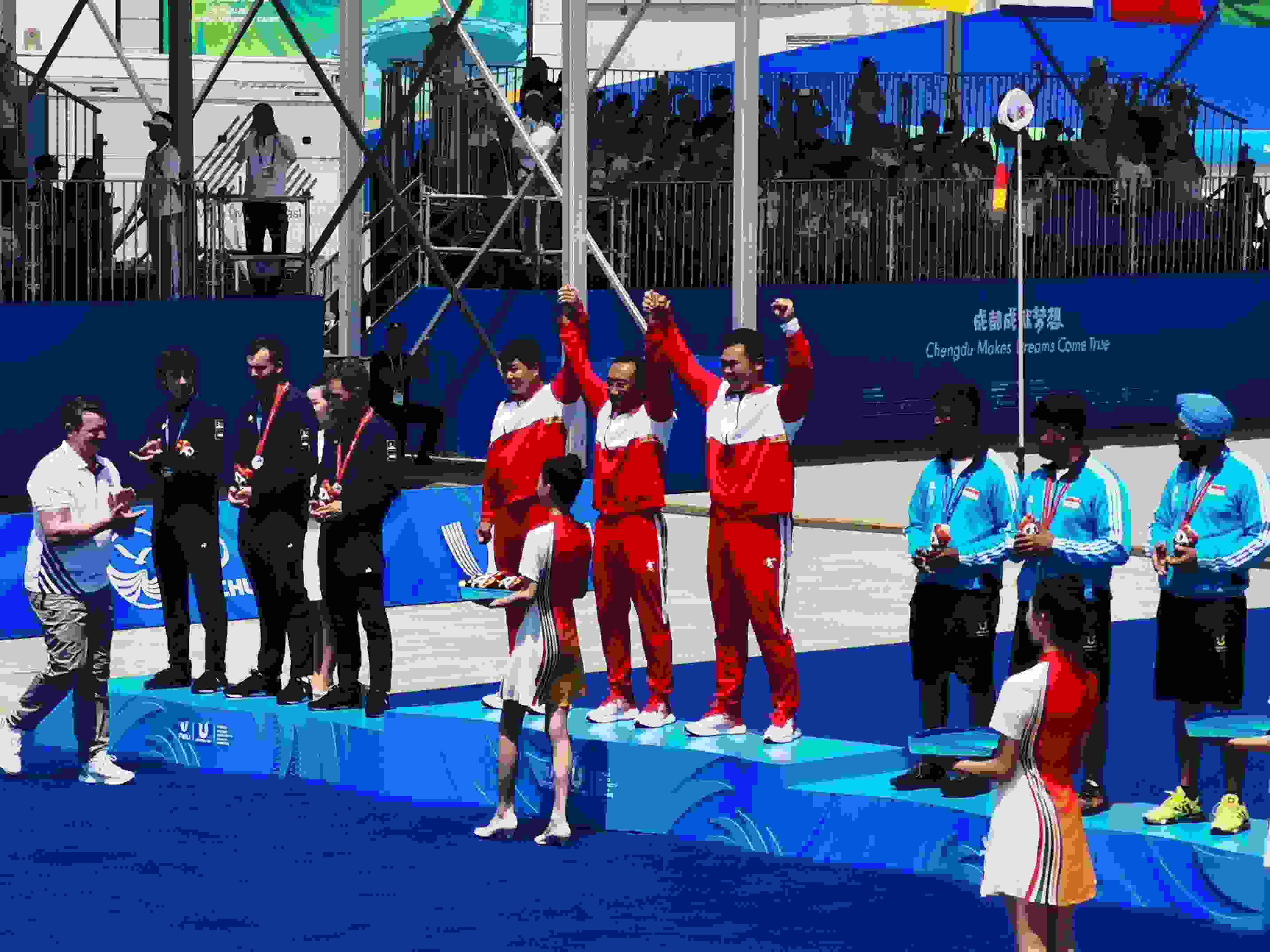 7月30日，在成都大運會男子復(fù)合弓團體頒獎儀式中，中國隊?wèi)c祝奪得冠軍。 人民網(wǎng)記者 楊磊攝