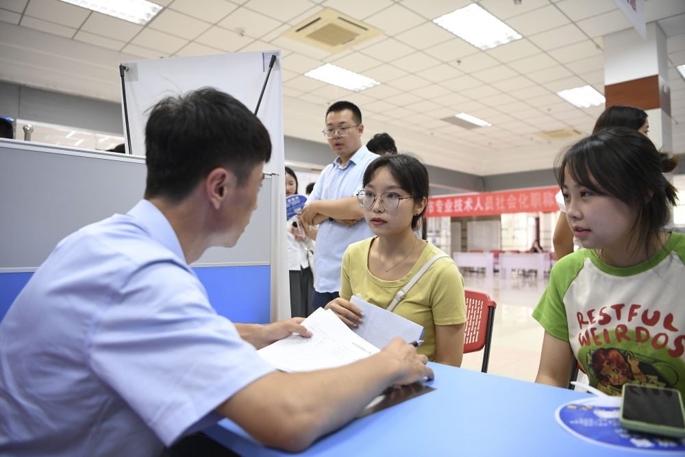 2023年7月29日，“揚(yáng)就業(yè)之帆，啟夢(mèng)想之旅”2023年寧夏（銀川）離校未就業(yè)高校畢業(yè)生招聘會(huì)在寧夏（銀川）人力資源服務(wù)產(chǎn)業(yè)園舉行。求職者（右）在招聘會(huì)現(xiàn)場(chǎng)與用人單位交流。新華社記者 馮開(kāi)華 攝