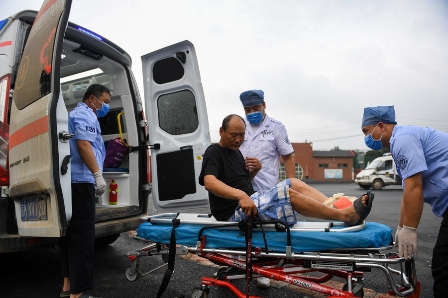 8月1日，在北京市門(mén)頭溝區(qū)妙峰山鎮(zhèn)妙峰山民族學(xué)校臨時(shí)安置點(diǎn)，北京急救中心工作人員在轉(zhuǎn)運(yùn)一名受傷村民。新華社記者 鞠煥宗 攝
