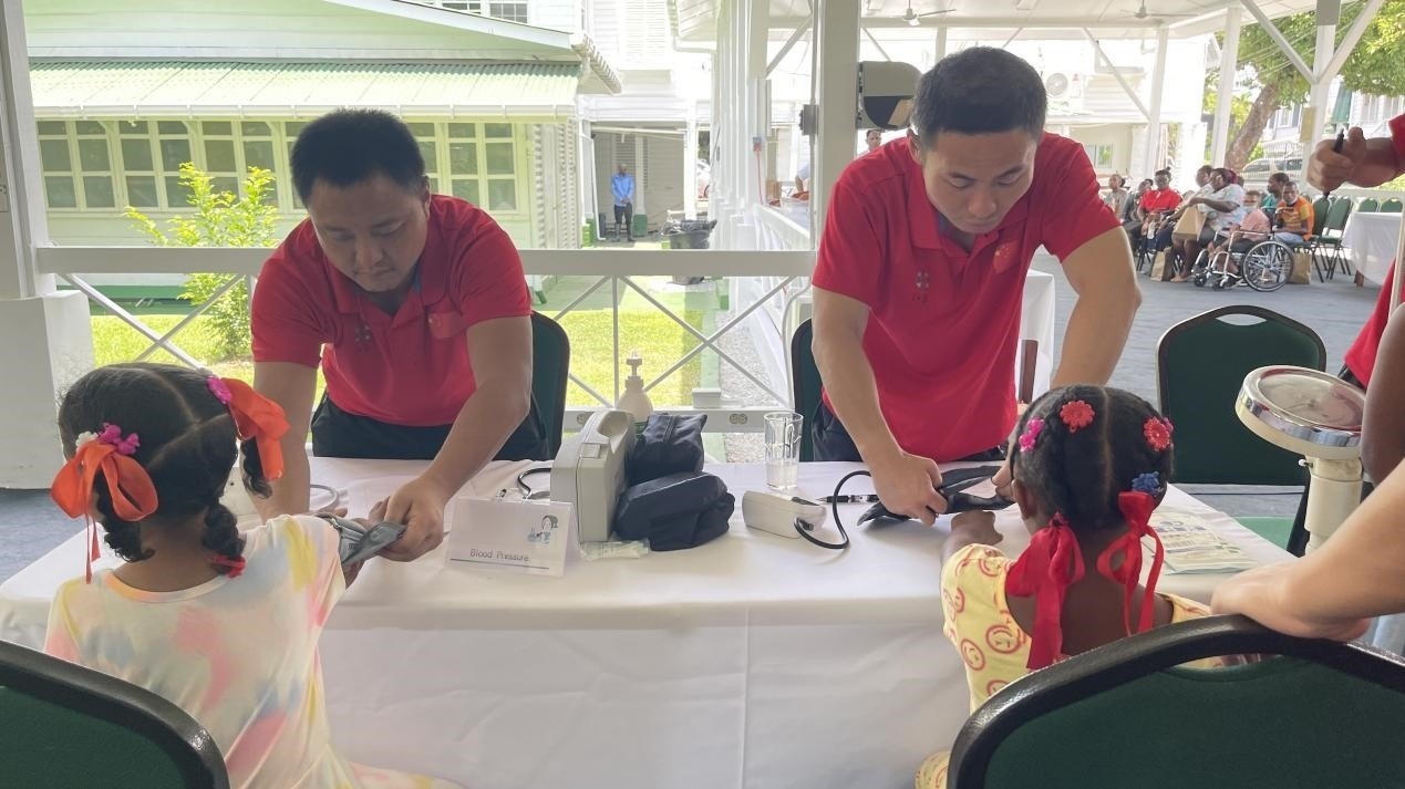 醫(yī)療隊(duì)員為福利院兒童進(jìn)行檢查。第18期援圭亞那醫(yī)療隊(duì)供圖