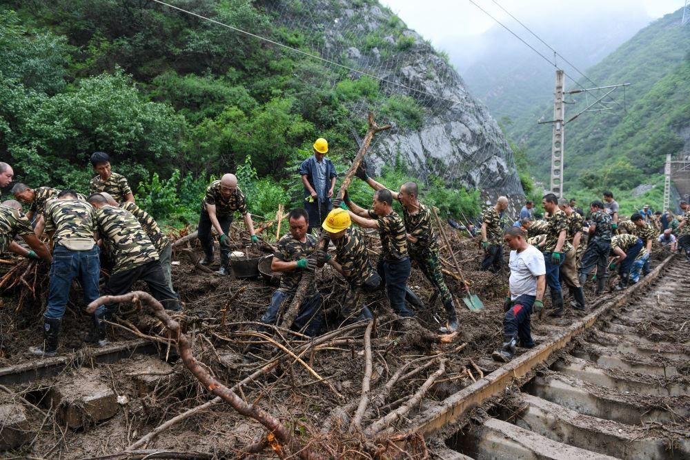 8月1日，在北京市門頭溝區(qū)水峪嘴村附近一段被阻斷的鐵路線上，中鐵六局工作人員在清理軌道上的雜物，全力恢復交通。新華社記者 鞠煥宗 攝