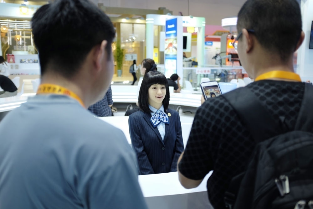 9月1日，媒體記者在國家會議中心與服務機器人互動。新華社記者 劉夢琪 攝