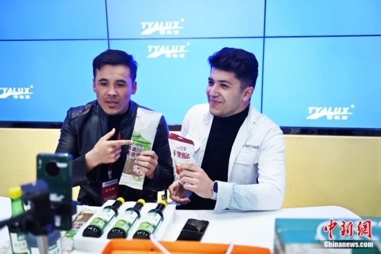 2023年3月，甘肅省慶陽市環(huán)縣電商創(chuàng)業(yè)孵化基地內(nèi)，來自蘭州文理學(xué)院的塔吉克斯坦留學(xué)生正在協(xié)助主播直播帶貨當(dāng)?shù)剞r(nóng)特產(chǎn)品。李亞龍 攝