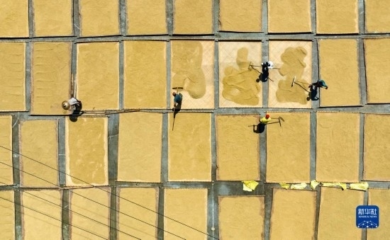 9月16日，在湖南省懷化市通道侗族自治縣萬(wàn)佛山鎮(zhèn)溪上村，村民在晾曬稻谷（無(wú)人機(jī)照片）。