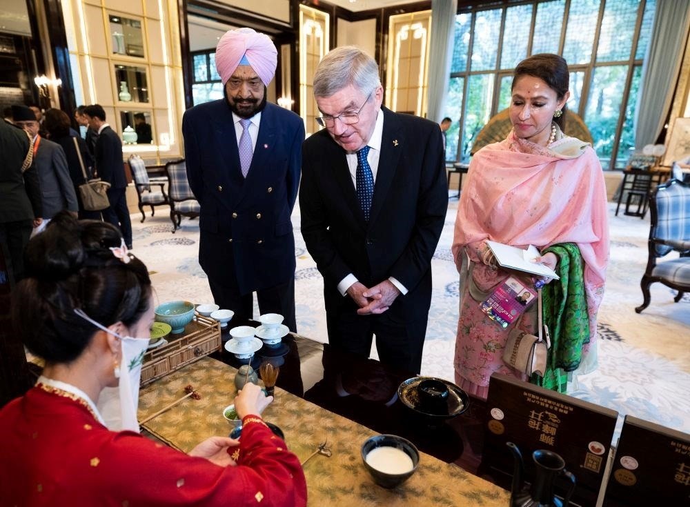 △歡迎宴會前，亞奧理事會代理主席辛格和夫人維尼塔、國際奧委會主席巴赫欣賞非遺展示。