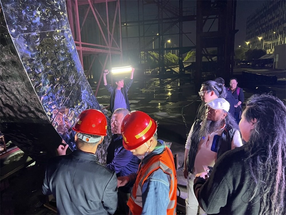 林崗（右二）和團隊查看主火炬制作進度。受訪者供圖