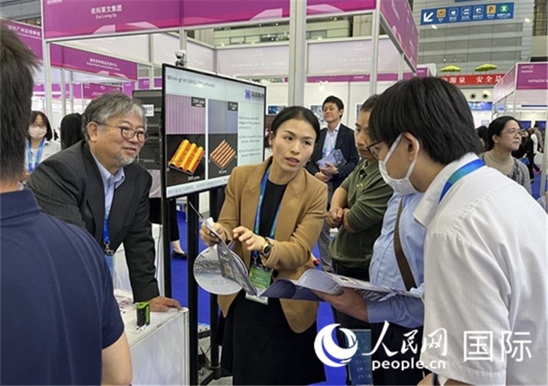 工作人員向參觀者介紹超級噴墨技術(shù)。（人民網(wǎng)記者 陳思攝）