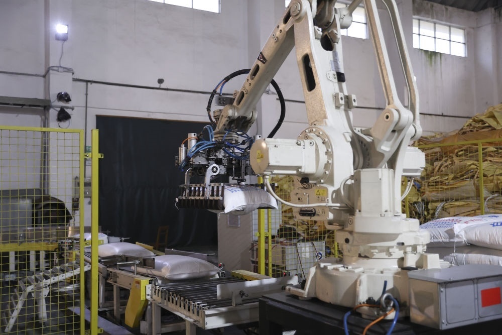 12月14日，在廣西來賓東糖鳳凰有限公司，機械臂在廠房碼放白砂糖成品。