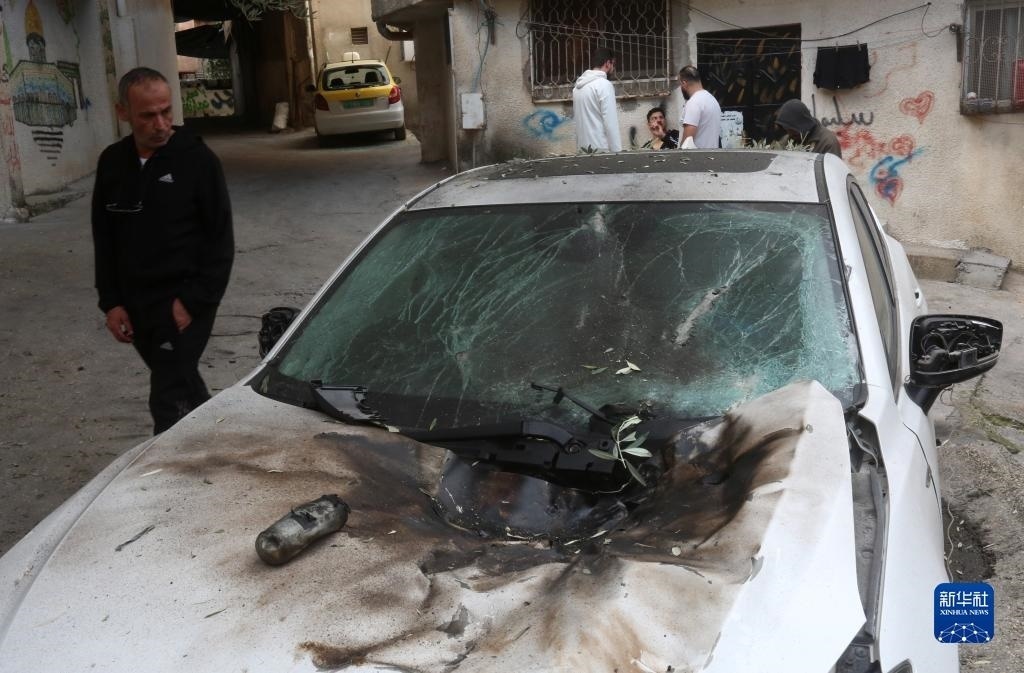 12月17日，在約旦河西岸城市圖勒凱爾姆附近的一處難民營(yíng)，人們查看在沖突中損毀的車輛。新華社發(fā)（尼達(dá)爾·艾仕塔耶?dāng)z）