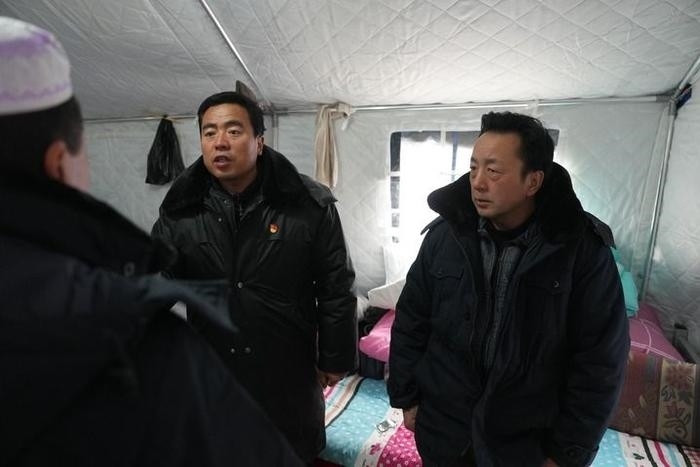 2023年12月22日，積石山縣大河家鎮(zhèn)大河村黨支部書記馬成忠（右二）在帳篷里和受災群眾交流。新華社記者 陳斌 攝