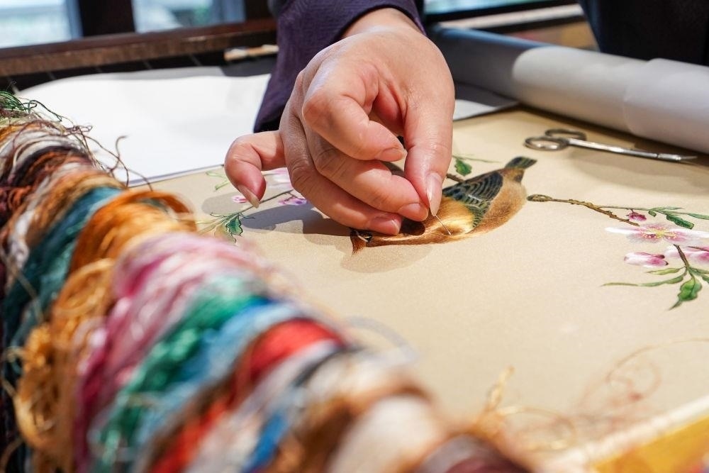 △2023年7月6日，盧建英在江蘇蘇州平江路的工作室內(nèi)刺繡。