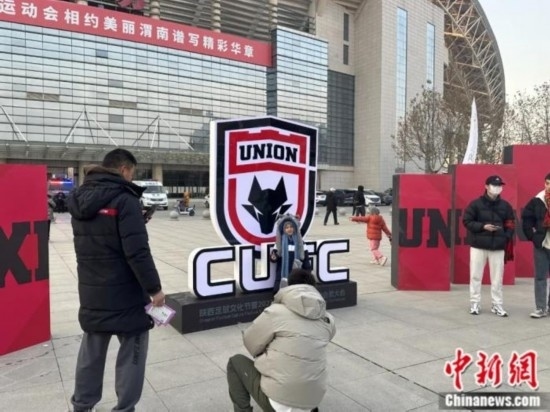 球迷們與隊(duì)徽合影。記者 卞立群 攝