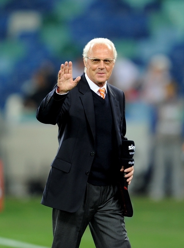 這是2010年7月7日，在南非德班舉行的2010年足球世界杯德國(guó)隊(duì)對(duì)陣西班牙隊(duì)的半決賽前，貝肯鮑爾接受電視臺(tái)采訪時(shí)和友人打招呼。新華社記者 王毓國(guó) 攝