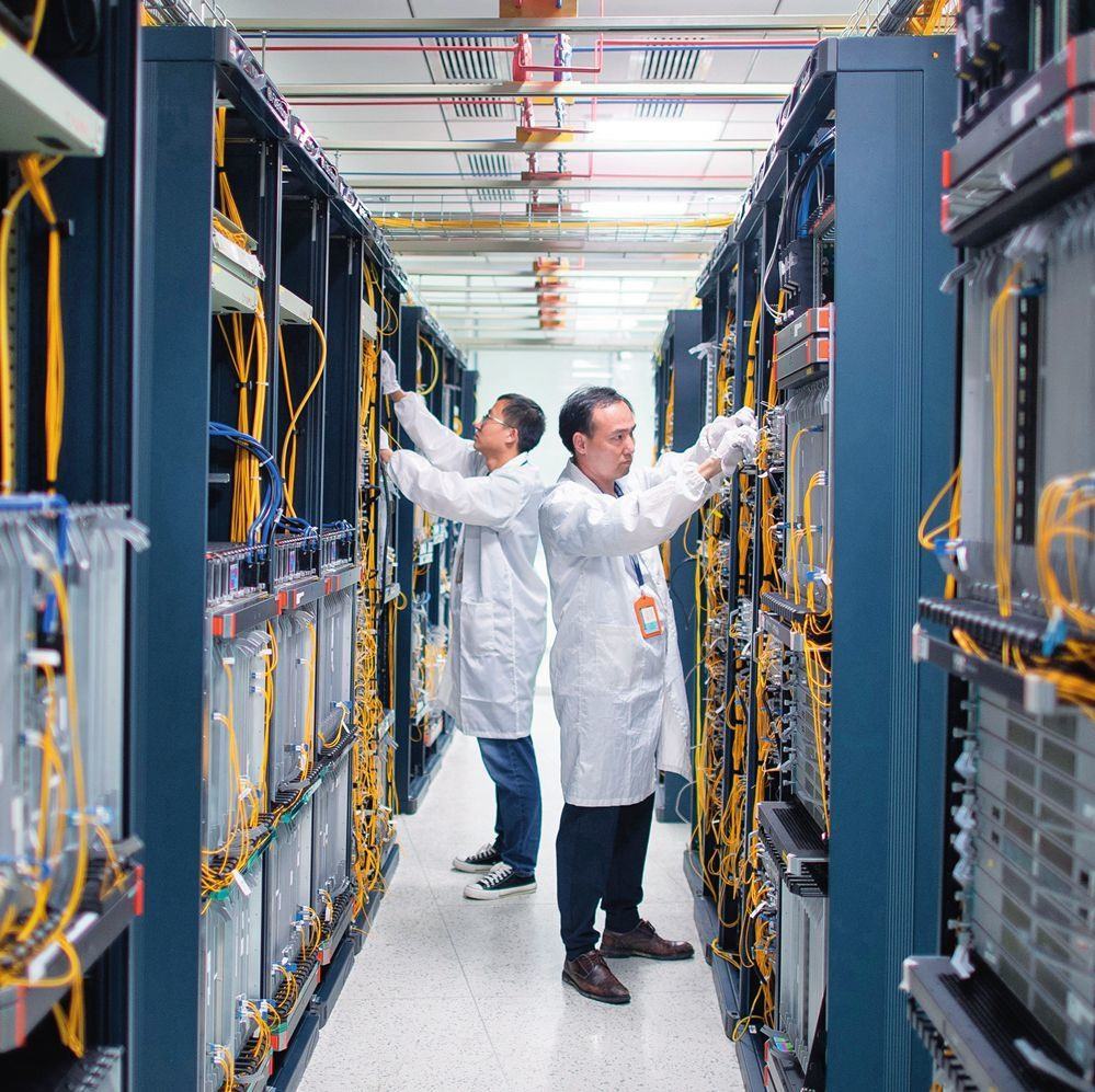 在位于武漢中國光谷的光電器件研發(fā)制造商——武漢光迅科技股份有限公司生產(chǎn)車間內(nèi)，技術(shù)人員在光模塊生產(chǎn)線作業(yè)（2023年4月11日攝）。程敏攝/本刊