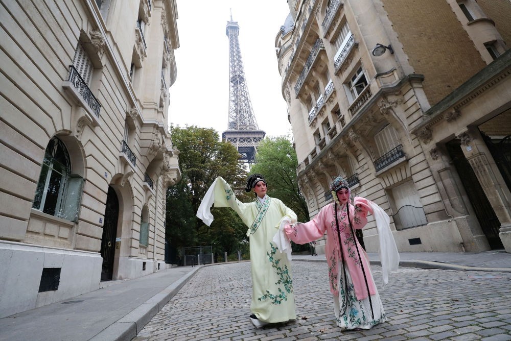 2023年9月13日，江蘇省演藝集團(tuán)昆劇院院長(zhǎng)施夏明（左）和江蘇省演藝集團(tuán)昆劇院國(guó)家一級(jí)演員孔愛萍在法國(guó)巴黎埃菲爾鐵塔附近參加昆曲快閃。新華社記者 高靜 攝