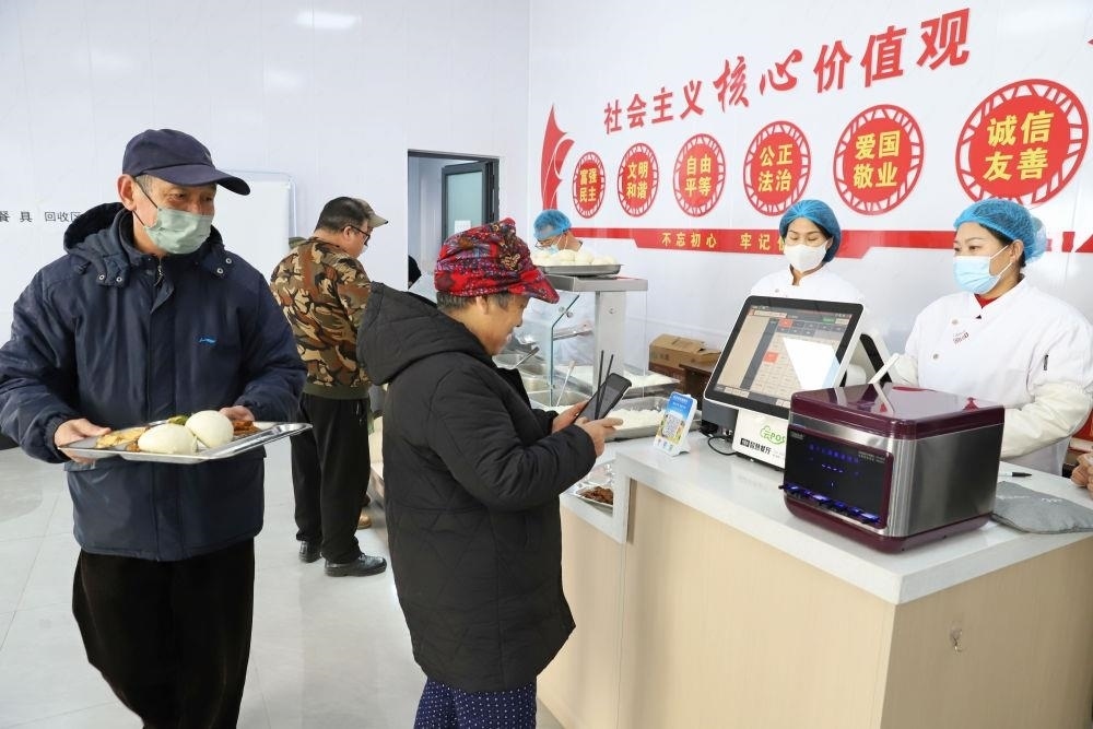 △2024年2月1日，市民在河北涿州市雙塔街道永濟秀園小區(qū)便民食堂內(nèi)購買午餐。