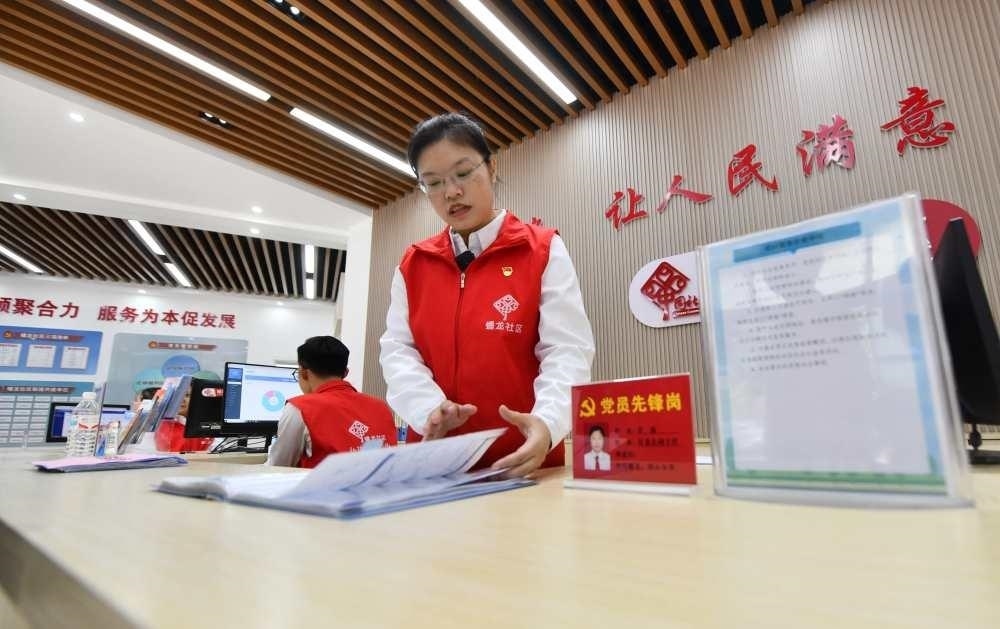 △2023年12月14日，廣西南寧市蟠龍社區(qū)，工作人員在為居民服務(wù)。