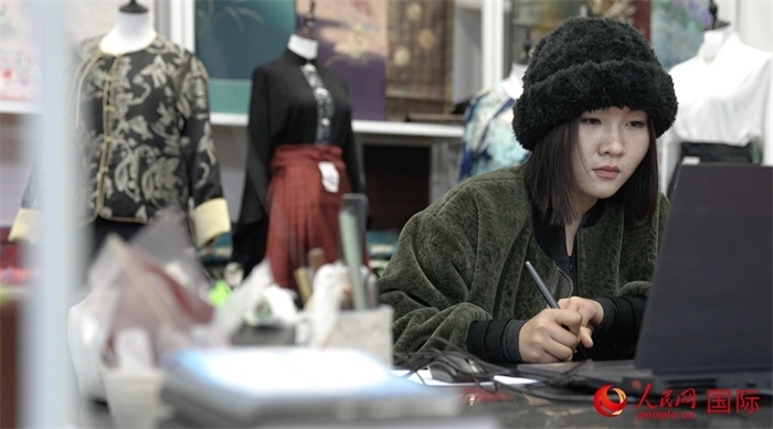 1月23日，在山東省菏澤市曹縣有愛云倉直播基地，張子晨正在設(shè)計漢服。 人民網(wǎng)記者 袁蒙攝