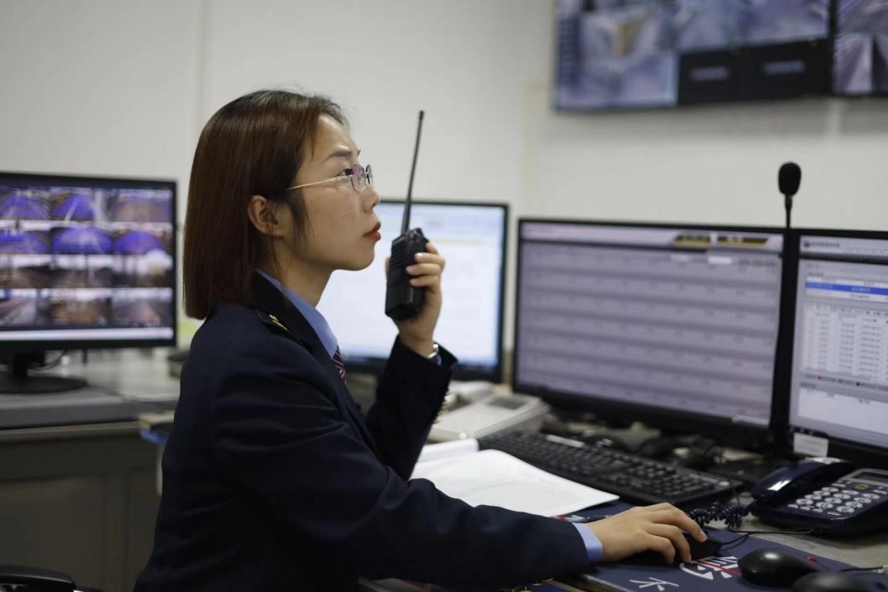 張華正在使用對(duì)講機(jī)溝通客運(yùn)工作情況。蔡紫妍攝