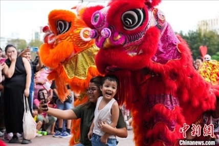 圖為舞獅表演吸引民眾合影。張興龍攝