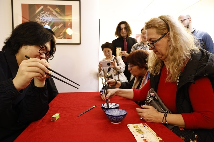 羅馬尼亞觀眾體驗用筷子夾花生。中國文化中心供圖