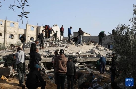  3月3日，在加沙地帶南部城市拉法，人們查看被以軍空襲破壞的建筑。新華社發(fā)（哈立德·奧馬爾攝）