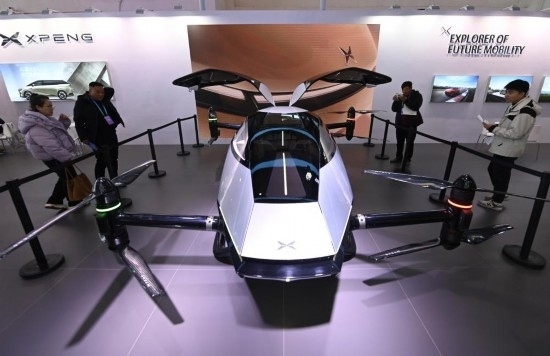 2023年12月1日，在鏈博會智能汽車鏈展區(qū)小鵬汽車展臺，參觀者觀看一臺智能飛行器。新華社記者蔡湘鑫攝