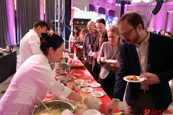 當?shù)貢r間3月7日晚，華盛頓聯(lián)合車站廣場舉行駐美使團“使館主廚挑戰(zhàn)賽”。圖為當?shù)孛癖娫谥袊古_前體驗中國美食。人民網記者 李志偉攝