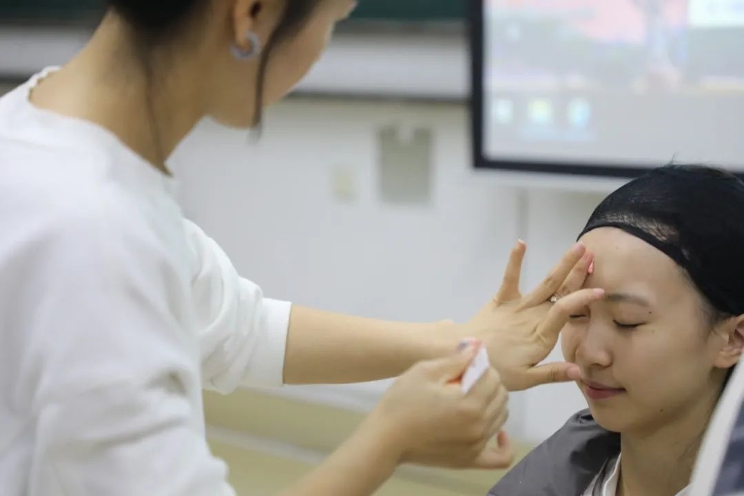 課堂上，一名學(xué)生在體驗上戲妝。學(xué)校供圖