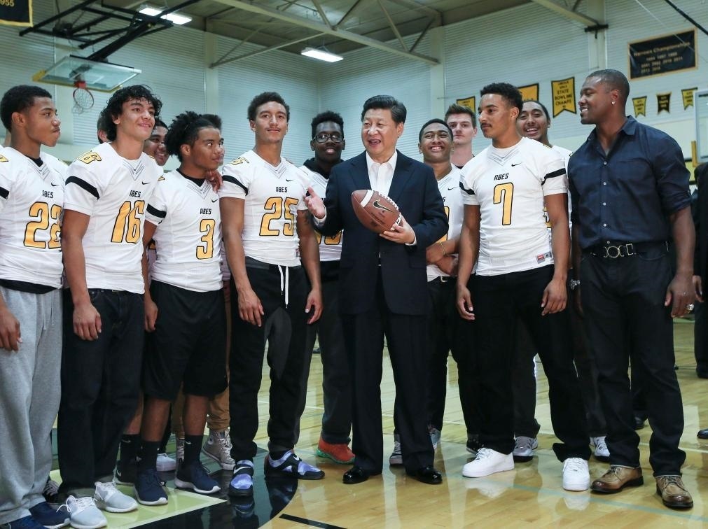 2015年9月23日，國家主席習(xí)近平參觀美國塔科馬市林肯中學(xué)。這是習(xí)近平在學(xué)校體育館，同上橄欖球訓(xùn)練課的學(xué)生們親切交談。新華社記者 蘭紅光 攝