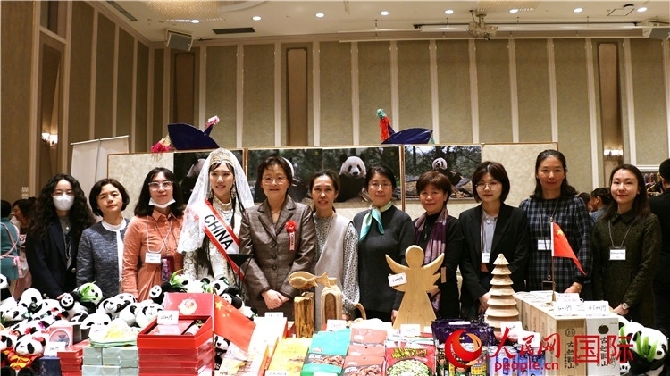 中國駐日本大使吳江浩夫人丁玥（左五）與使館人員在展位前合影留念。人民網 許可攝