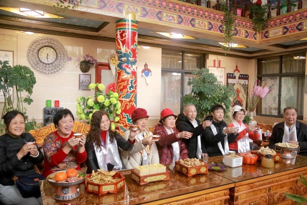 游客們?nèi)胱∶袼藓螅e杯共飲酥油茶。新華社記者 邱星翔 攝