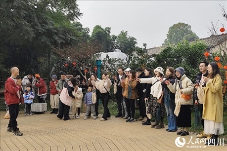 葉科（左一）給前來(lái)參與活動(dòng)的“柑爸柑媽”介紹生態(tài)種植果。人民網(wǎng)記者朱虹攝