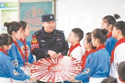 圖為公安民警給學(xué)生們講解國(guó)家安全知識(shí)。張鷹攝